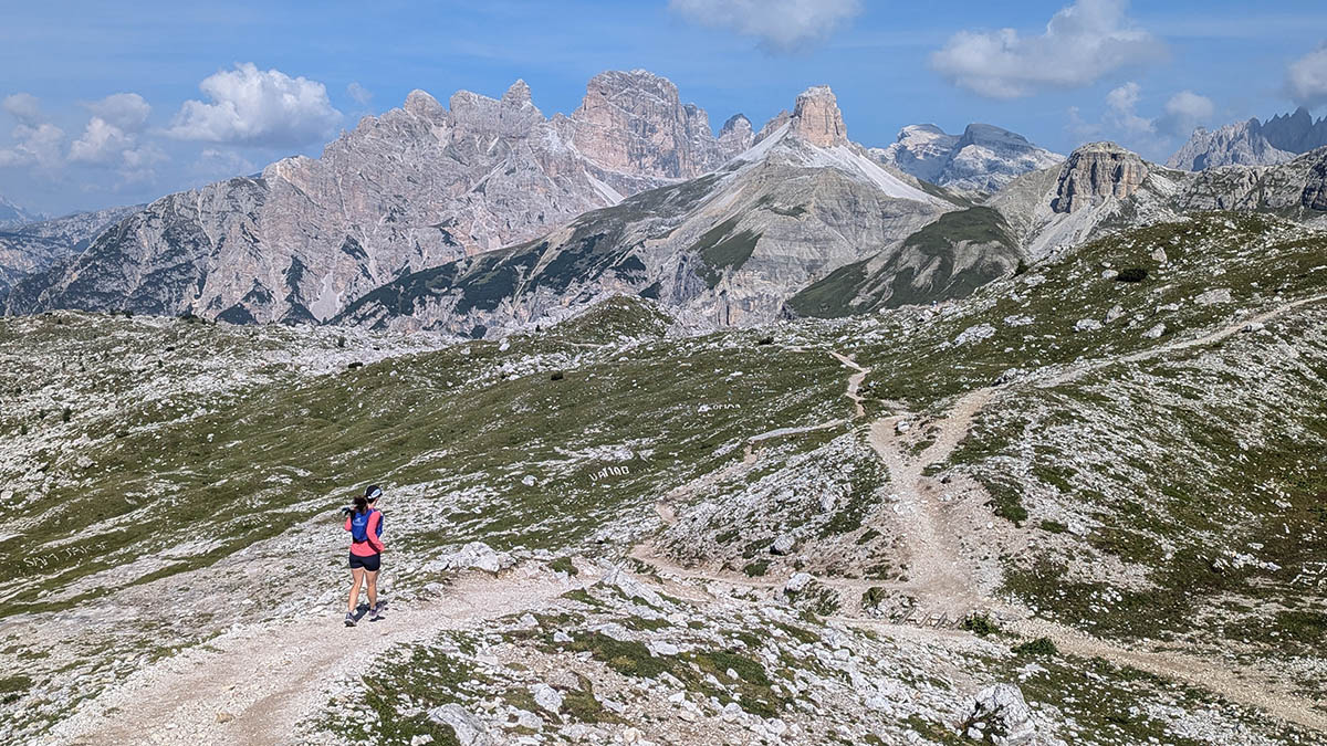 A Woman Running On A Trail Through The Dolomites In Italy